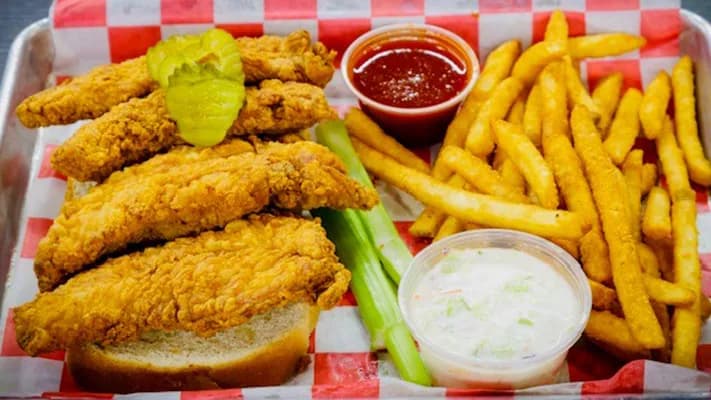 Fried chicken tenders with fries, celery, coleslaw and sauce