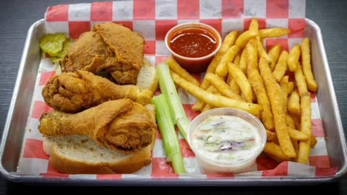 Fried chicken legs and thighs with fries, coleslaw and celery