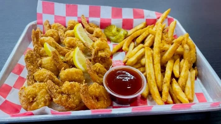 Fried shrimp with lemon, fries and cocktail sauce